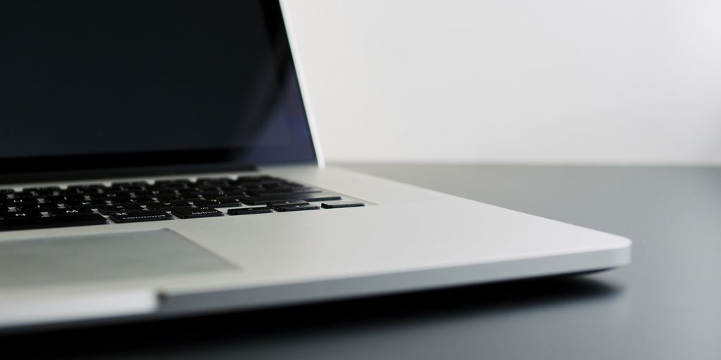 silver laptop computer on black table